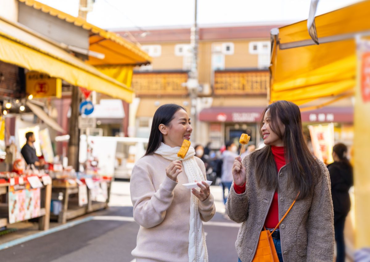 Asiatische Freundinnen essen Street Food in Tokio
